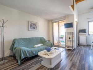 una sala de estar con un sofá y una mesa en Apartment Les Terrasses de la Mer-2 by Interhome, en Saint-Aygulf