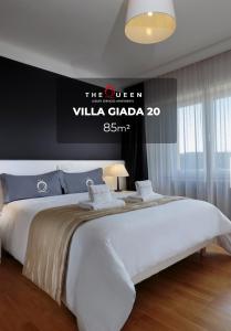 1 dormitorio con 1 cama grande y un cartel en la pared en The Queen Luxury Apartments - Villa Giada, en Luxemburgo