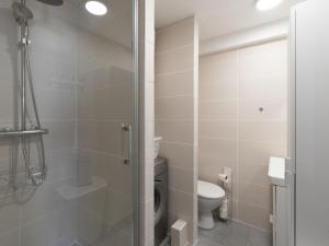 ein Bad mit einem WC und einer Glasdusche in der Unterkunft Apartment Los Amigos-14 by Interhome in Le Grau-du-Roi