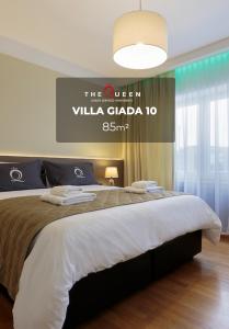 a bedroom with a large bed with a sign on the wall at The Queen Luxury Apartments - Villa Giada in Luxembourg