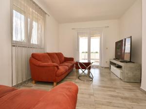 a living room with a couch and a television at Holiday Home Dalmatina by Interhome in Maslenica