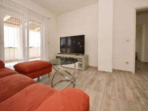 a living room with a couch and a table and a tv at Holiday Home Dalmatina by Interhome in Maslenica