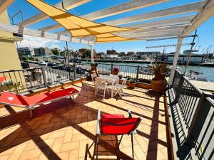 a deck with chairs and tables on a balcony at Clementina House in Fiumicino