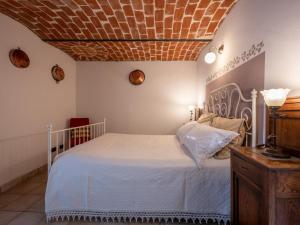 a bedroom with a white bed and a brick ceiling at Apartment Casa Domenica by Interhome in Monastero Bormida