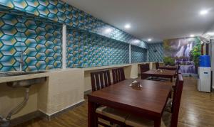 a restaurant with a table and a sink and blue tiles at Treebo Trend Kruthika Inn in Hyderabad