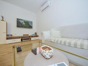 ein Wohnzimmer mit einem Sofa und einem Tisch in der Unterkunft Holiday Home House of pleasant dreams by Interhome in Veli Iž