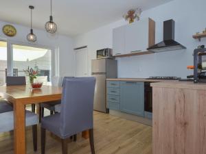 eine Küche mit einem Holztisch und einem Esszimmer in der Unterkunft Holiday Home House of pleasant dreams by Interhome in Veli Iž