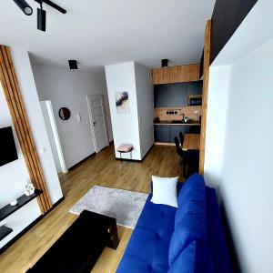 a living room with a blue couch and a kitchen at GOOD PLACE Zator in Zator