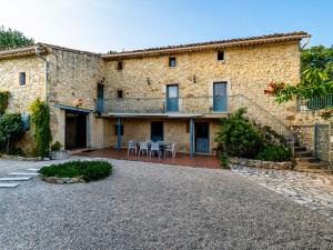 ein großes Steinhaus mit einer Terrasse und einer Treppe in der Unterkunft Holiday Home Le Mas d'Adélaïs by Interhome in Baron