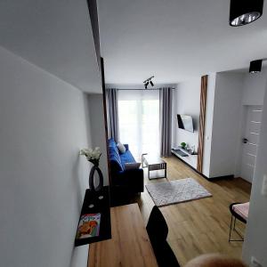 a living room with a blue couch and a window at GOOD PLACE Zator in Zator +13 photos