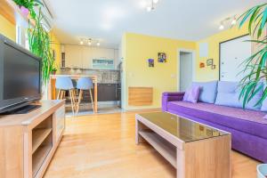 un soggiorno con divano viola e TV di Apartment Yellow Duck - CITY CENTER a Makarska