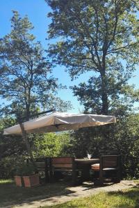 un parasol blanc assis à côté d'une table et de bancs dans l'établissement Holiday Home Villa La Chiesa by Interhome, à Bosco