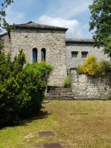 un vecchio edificio in pietra con due finestre sopra di Holiday Home Villa La Chiesa by Interhome a Bosco