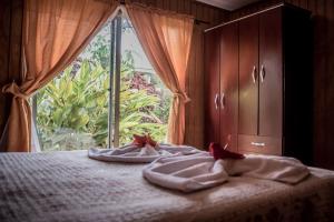 - une chambre avec 2 serviettes sur un lit et une fenêtre dans l'établissement Hostal y Cabañas Aorangi, à Hanga Roa