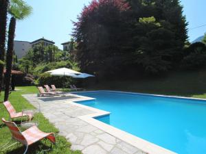 una piscina con sillas y sombrillas en Villa Al Piano by Interhome, en Castelveccana