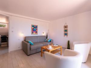 a living room with a couch and a table at Apartment Mont des Oiseaux by Interhome in Hyères