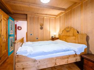 a large wooden bed in a room with wooden walls at Chalet Cesa Galaldriel-3 by Interhome in Penia