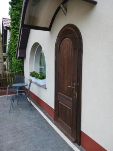 a wooden door on a building with a chair at Apartament w cichej dzielnicy in Kołobrzeg