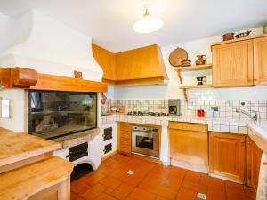 a kitchen with wooden cabinets and a tile floor at Chalet Cesa Galadriel-3 by Interhome in Penia +65 photos