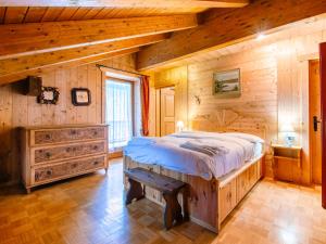 a bedroom with a bed in a log cabin at Chalet Cesa Galadriel-3 by Interhome in Penia