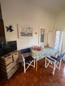 een keuken met een tafel en stoelen en een koelkast bij La casetta di Chloè residence con Piscina in Santa Marinella