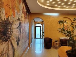 a hallway with a large painting on the wall at Семеен Хотел "Булаир" in Burgas City