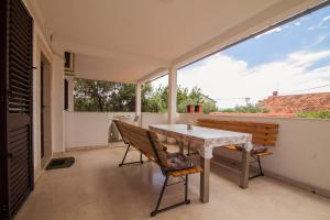 a dining room with a table and chairs on a balcony at Kos Apartments in Bol