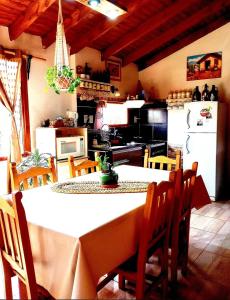 cocina con mesa y sillas y cocina con nevera en Cabaña Onty en El Calafate