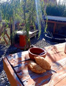Cabaña Onty في إل كالافاتي: طاولة خشبية عليها صحن وبعض الخبز