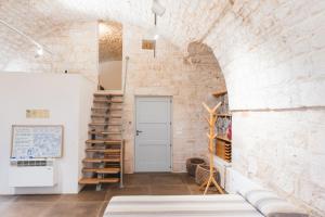 a room with a staircase and a brick wall at Ostello dei Giardini di Pomona in Cisternino