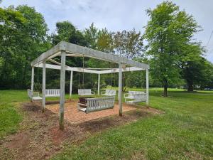 a pavilion with three benches in a park at Winridge Manor in Madison Heights