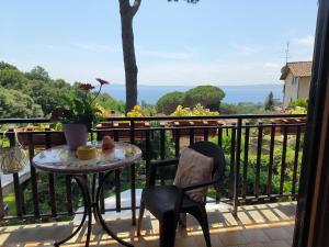 una mesa y una silla en un balcón con vistas en 'La perla del lago' alloggio turistico, en Trevignano Romano