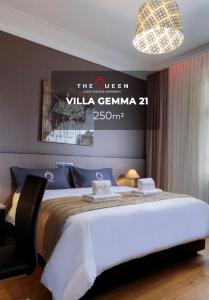 a hotel room with a bed with a sign on the wall at The Queen Luxury Apartments - Villa Gemma in Luxembourg
