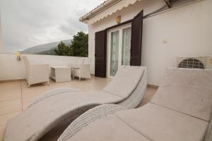 a balcony with wicker chairs and a table at Kos Apartments in Bol
