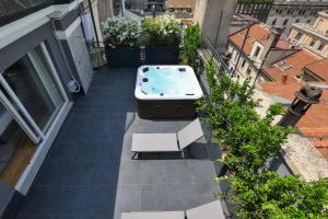 uma banheira de hidromassagem na varanda de um edifício em PRESTIGE BOUTIQUE APARTHOTEL - Piazza Duomo View em Milão