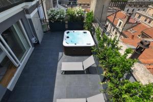 una vasca idromassaggio sul balcone di un edificio di PRESTIGE BOUTIQUE APARTHOTEL - Piazza Duomo View a Milano