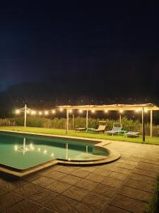 a swimming pool at night with lights on a patio at La Rugantina in Cortona
