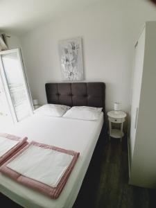 a bedroom with a large white bed with a window at Tonka Apartments in Gradac