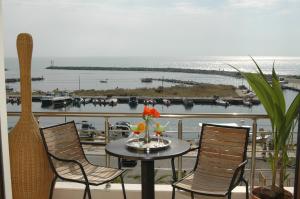una mesa y sillas en un balcón con vistas al océano en Porto Del Sol Hotel, en Paralia Katerinis