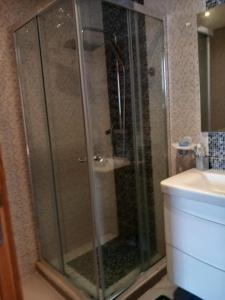 a glass shower in a bathroom with a sink at Bel Appartement à Mansbay in Mansouria