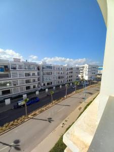 an empty street in front of a large apartment building at Bel Appartement à Mansbay in Mansouria