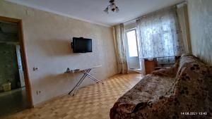 a bedroom with a bed and a tv on the wall at Apartment Tiraspol Center in Tiraspol