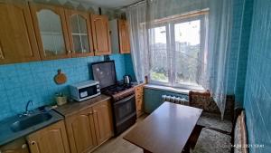 a kitchen with a stove and a sink and a window at Apartment Tiraspol Center in Tiraspol