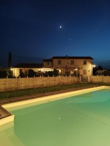 a swimming pool in front of a house at night at La Rugantina in Cortona