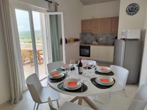 mesa de comedor con sillas y mesa con copas de vino en Apartment Amici Miei di Ponente by Interhome, en San Corrado di Fuori