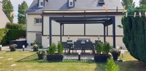 a patio with a table and chairs in a backyard at Chez Marie in Dol-de-Bretagne