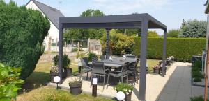 a gazebo with a table and chairs in a garden at Chez Marie in Dol-de-Bretagne +5 photos