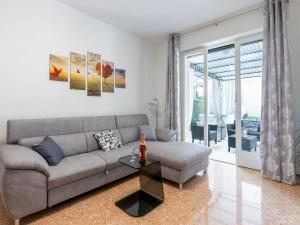 ein Wohnzimmer mit einem Sofa und einem Tisch in der Unterkunft Apartment Giardino al Mare by Interhome in Sanremo