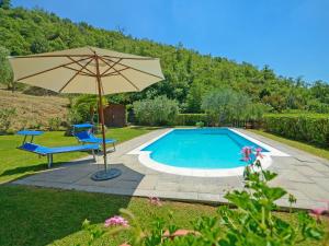 - une piscine avec un parasol, une chaise et une table dans l'établissement Holiday Home Il Farinaio by Interhome, à Cortone