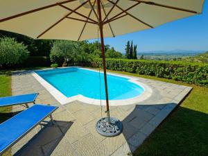 - un parasol à côté de la piscine dans l'établissement Holiday Home Il Farinaio by Interhome, à Cortone